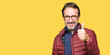 © Krakenimages.com - Middle age handsome man wearing glasses and winter coat doing happy thumbs up gesture with hand. Approving expression looking at the camera showing success.