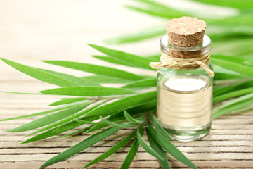 Sticker - Tea tree essential oil in the galss bottle, on the wooden board