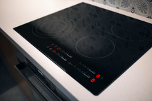New electric stove with induction cooktop in kitchen, closeup. Modern apartment with touchscreen cooktop