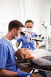 © gpointstudio - Dentist and his assistant working with dental microscope