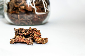 Wall Mural - cut dry root of Rhodiola rosea in a glass jar on natural white background