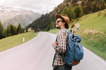 inspired young man with sincere smile looking around enjoying amazing italian nature and forest land