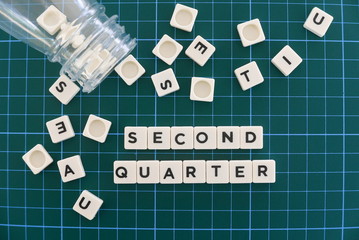 Second quarter word made of square letter word on green square mat background.