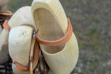 Wooden Shoes In Dutch Style Lying In A Basket Of Wickerwork