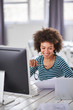© nenadaksic - Smiling cute mixed race businesswoman dressed casual sitting in office and looking at paperwork.