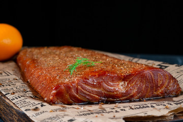 Smoked Fillet salmon fish with pepper and salt on wooden cutting board on dark background