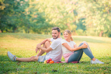 Wall Mural - Portrait image of Young couple enjoying in the park at sunset. Concept romantic and love. Warm tone.