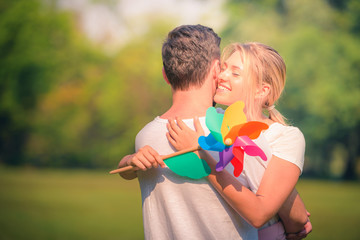 Wall Mural - Portrait image of Young couple enjoying in the park at sunset. Concept romantic and love. Warm tone.