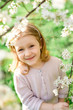 © Natali44 - Portrait of cute and pretty little girl in spring blooming trees. Adorable little girl smiling in blooming garden on sunny day. Child and flowers. Childhood & natural tenderness. Children's day.