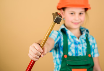 hammer in hand of small girl repairing in workshop. Foreman inspector. Little girl in helmet with hammer. Kid worker in hard hat. Labor day. 1 may. repair shop. fixing everything