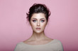 © Dragosh - Beauty fashion brunette model with charming makeup looking at camera isolated on pink background in warm tones.