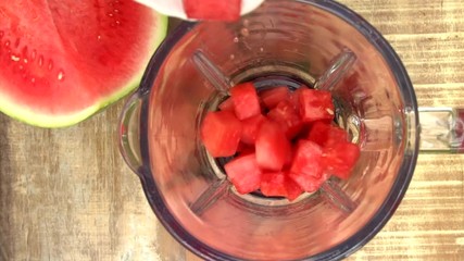 Wall Mural - pouring slices of watermelon in blender, top view slow motion video