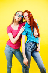 lifestyle people concept: two pretty young school teenage girls having fun happy smiling on yellow background close up