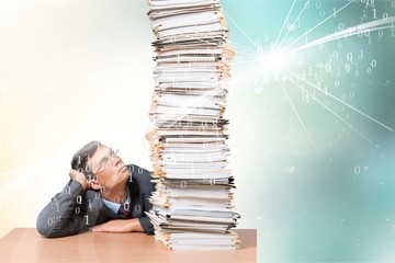 Young man looking on huge stack of papers, isolated on white background