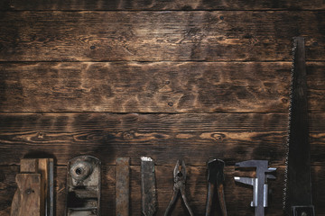 Old construction tools on a wooden workbench flat lay background with copy space. Carpenter table. Woodwork.