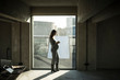 © Westend61 - Pregnant businesswoman standing at office window, using smartphone