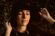 © Alberto Menendez/ADDICTIVE STOCK - Young sensual brunette wearing black hat and accessories while posing in sunlight keeping eyes closed