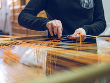 Crop Person Holding Threads On Loom