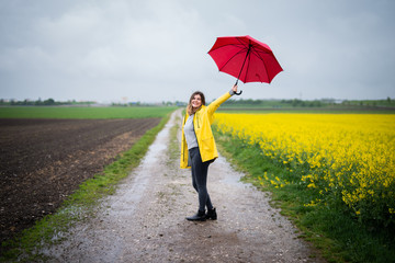 Junge Frau tanzt glücklich im Regen 