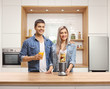 © Ljupco Smokovski - Young man and woman in a kitchen posing with fruits in a blender and a fresh juice