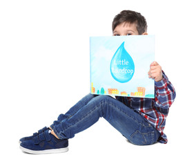 Wall Mural - Cute little boy with book on white background