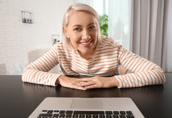 Canvas Print - Mature woman using video chat on laptop at home, view from web camera