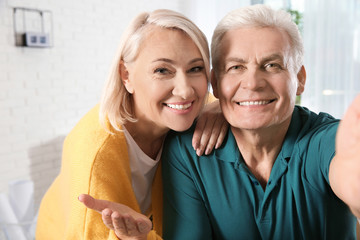 Canvas Print - Mature couple using video chat at home, view from web camera