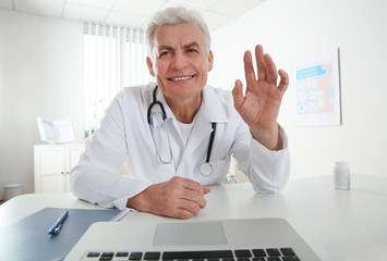 Canvas Print - Doctor consulting patient using video chat in clinic, view from web camera