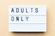 © bankrx - White lightbox with word adults only on wood background