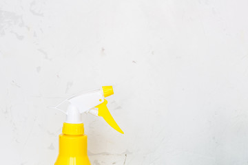 Simple yellow plastic hand spray bottle on gray background.