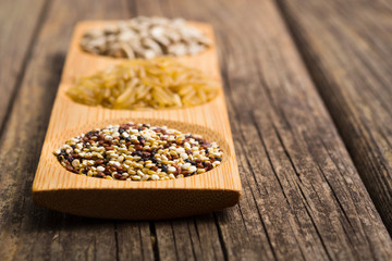 Wall Mural - sunflower seeds, unpeeled rice, quinoa seeds on old wooden table