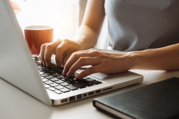 Social media and Marketing virtual icons screen of businesswoman typing keyboard with laptop computer at office at morning light