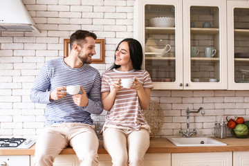 Lovely young couple drinking tea in kitchen