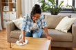 household, cleaning and people concept - happy african american woman or housewife wiping table by tissue or rag at home