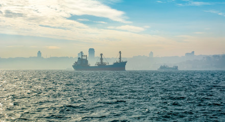 Wall Mural - Muslim architecture and water transport in Turkey - Beautiful View touristic landmarks from sea voyage on Bosphorus. Cityscape of Istanbul at sunset - old mosque and turkish steamboats, view on Golden