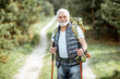 © rh2010 - Portrait of a senior man with backpack and trekking sticks on the way in the woods