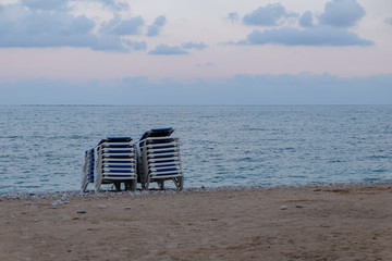 view of the beach at sunset with beach loungers