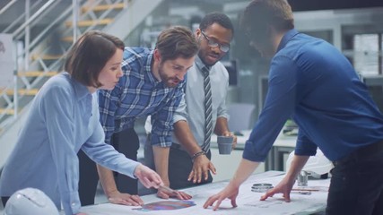 Poster - In the Industrial Engineering Facility: Diverse Group of Engineers, Technicians, and Specialists on a Meeting, Have Discussion, Analyze Engine Design Technical Drafts that are Lying on the Table