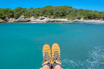Wall Mural - Selfie of hiking shoes, mediterranean blue water background in Menorca, Balearic islands, Spain