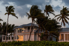 Coast House Beachfront Waterfront Vacation Home, House During Evening Sunset With Nobody In Florida, Gulf Of Mexico, Stormy Weather And Wind On Palm Trees
