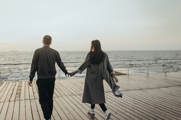 Wall Mural - Beautiful loving couple walking at sunset, authentic love