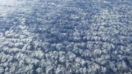 Wall Mural - 4K, Wonderful view of the sky and clouds with the light the sun from above, as seen through airplane window. Beautiful view of passenger POV traveling by air. Traveler in cabin at plane-Dan