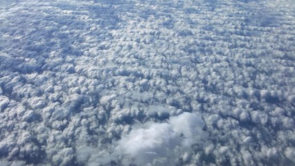Wall Mural - 4K, Wonderful view of the sky and clouds with the light the sun from above, as seen through airplane window. Beautiful view of passenger POV traveling by air. Traveler in cabin at plane-Dan