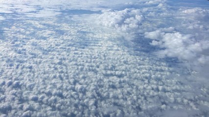 Wall Mural - 4K, Wonderful view of the sky and clouds with the light the sun from above, as seen through airplane window. Beautiful view of passenger POV traveling by air. Traveler in cabin at plane-Dan