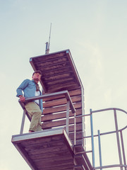 young man dressed casual on surveillance walkway on the beach