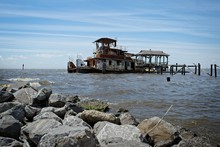 A Rusted Out Abandon Tug Boat In The Water Just Off The Shore Of Lake Pontchartrain In Madisonville, Louisiana
