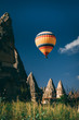 © Alvaro - A Colorful balloon flying in the middle of rocky mountains in cappadocia, Goreme, Turkey
