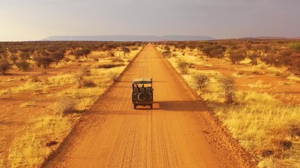 aerial of a safari jeep traveling on the plains of africa, at erindi game preserve, namibia with nat