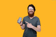 © Vulp - Photo of handsome bearded guy  pointing at his mobile while looking at camera