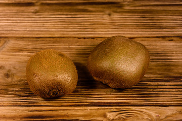 Two kiwi fruits on a wooden table